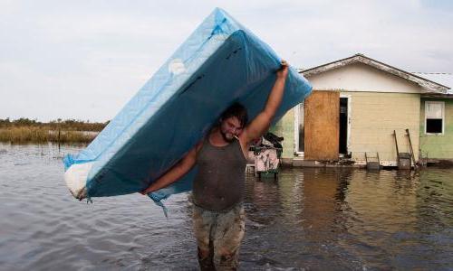 A person hauling a mattress during a flood